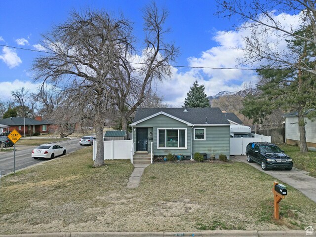 1054 34th St, Ogden, UT 84403 - bungalow featuring a mountain view, roof with shingles, a front yard, and fence