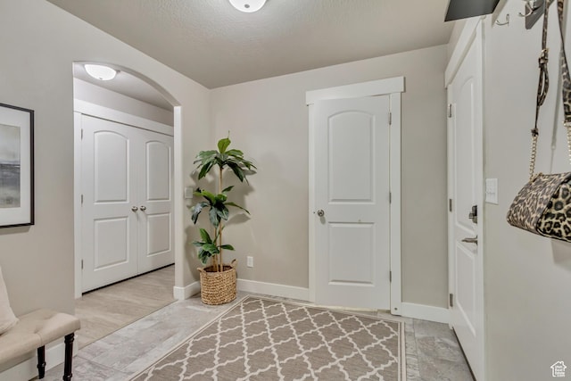 1879 E Tickville Cir, Eagle Mountain, UT 84005 - entryway featuring arched walkways, a textured ceiling, and baseboards