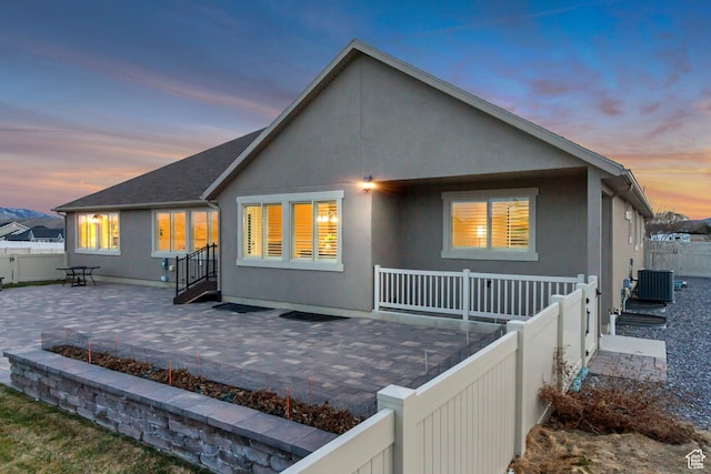 1879 E Tickville Cir, Eagle Mountain, UT 84005 - rear view of house featuring a fenced backyard, central AC unit, a patio, and stucco siding