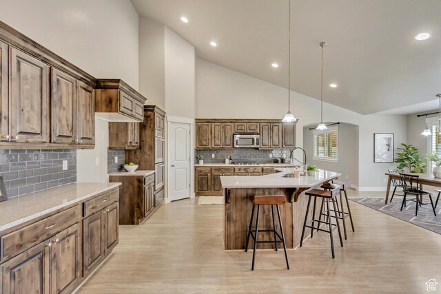 1879 E Tickville Cir, Eagle Mountain, UT 84005 - kitchen featuring a large island with sink, a sink, backsplash, high vaulted ceiling, and appliances with stainless steel finishes