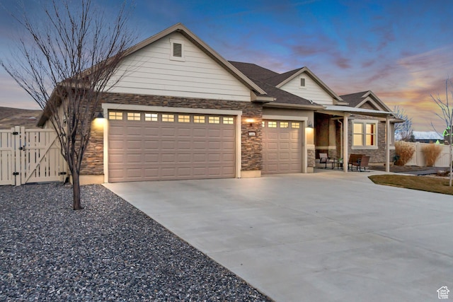 1879 E Tickville Cir, Eagle Mountain, UT 84005 - view of front of property with a gate, stone siding, concrete driveway, fence, and a garage