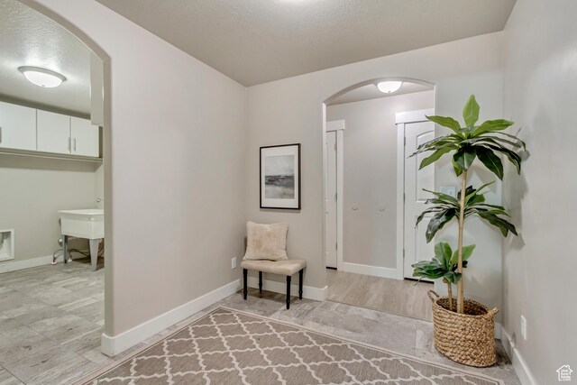 1879 E Tickville Cir, Eagle Mountain, UT 84005 - sitting room with arched walkways, a textured ceiling, and baseboards