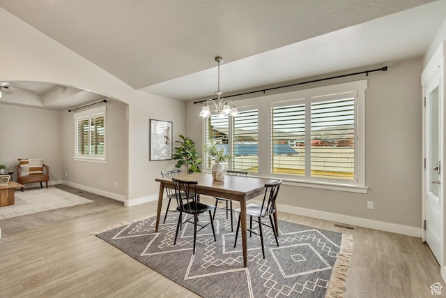 1879 E Tickville Cir, Eagle Mountain, UT 84005 - dining room with arched walkways, light wood-style flooring, visible vents, and baseboards