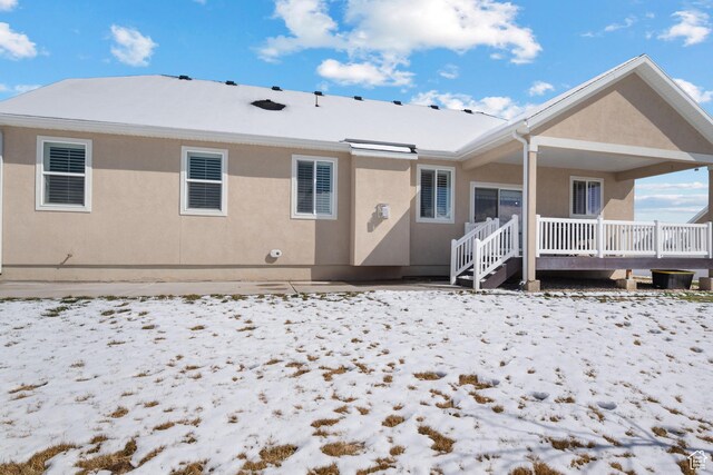 snow covered house with stucco siding