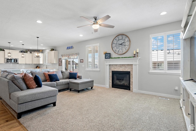 living room with baseboards, ceiling fan, a fireplace, and recessed lighting