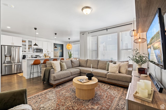 living area featuring dark wood-style flooring and recessed lighting