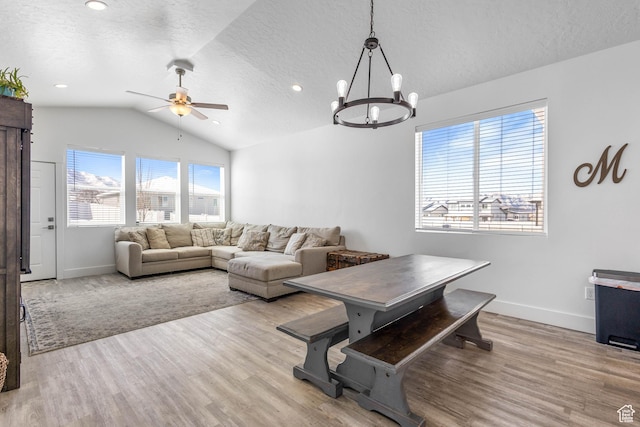 671 W 660 S, Tooele, UT 84074 - living area featuring a textured ceiling, baseboards, vaulted ceiling, wood finished floors, and ceiling fan with notable chandelier