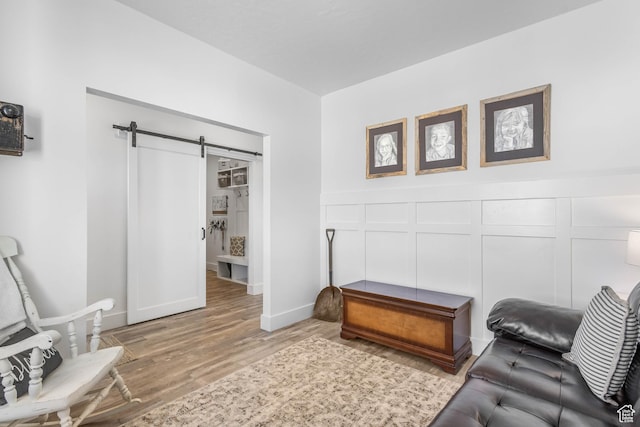 671 W 660 S, Tooele, UT 84074 - living room with a barn door, wood finished floors, wainscoting, and a decorative wall