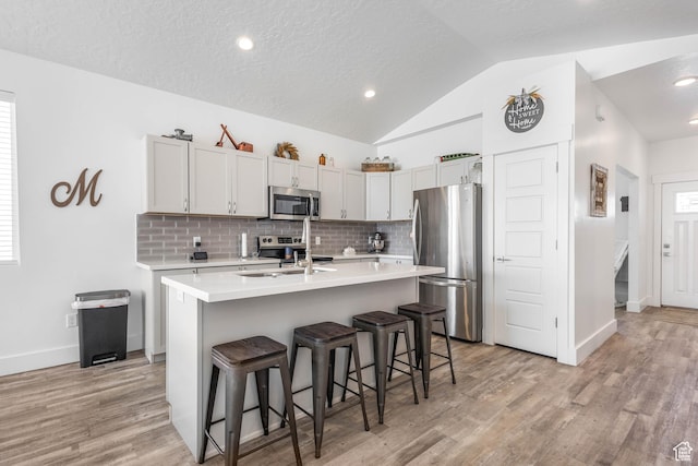 671 W 660 S, Tooele, UT 84074 - kitchen with a sink, stainless steel appliances, a kitchen breakfast bar, backsplash, and light countertops