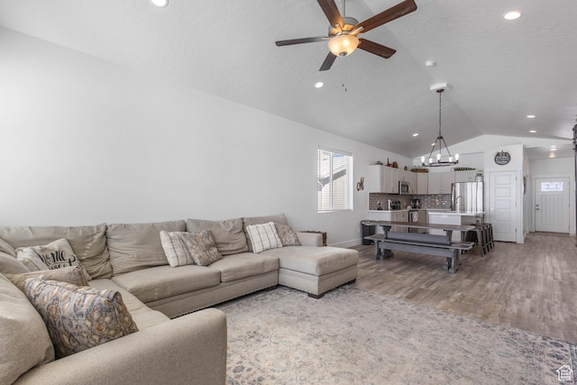 671 W 660 S, Tooele, UT 84074 - living area featuring lofted ceiling, light wood-style flooring, baseboards, recessed lighting, and ceiling fan with notable chandelier