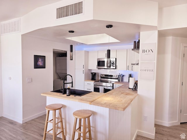 900 Bitner Rd Unit G-32, Park City, UT 84098 - kitchen featuring a sink, visible vents, appliances with stainless steel finishes, and stacked washer / dryer