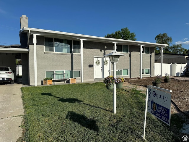 169 S Woodland Dr E, Orem, UT 84097 - split foyer home featuring brick siding, a chimney, concrete driveway, and a carport