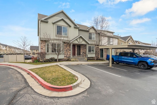 view of front of house with covered and uncovered parking, stone siding, and stucco siding
