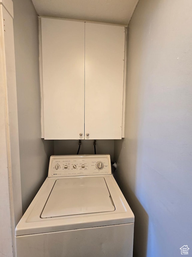 washroom featuring washer / dryer and cabinet space
