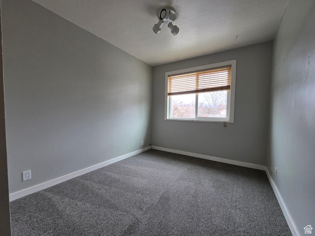unfurnished room featuring carpet and baseboards