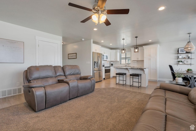 living room with recessed lighting, visible vents, baseboards, and a ceiling fan