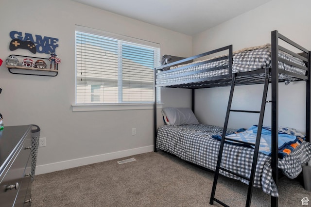 carpeted bedroom with visible vents, multiple windows, and baseboards