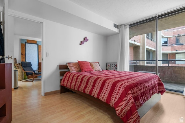 115 S 1100 E Unit 614, Salt Lake City, UT 84102 - bedroom featuring light wood-type flooring, expansive windows, access to outside, and baseboards