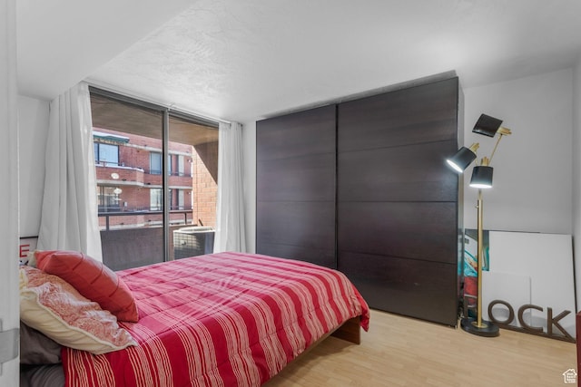 115 S 1100 E Unit 614, Salt Lake City, UT 84102 - bedroom featuring wood finished floors, access to exterior, and expansive windows