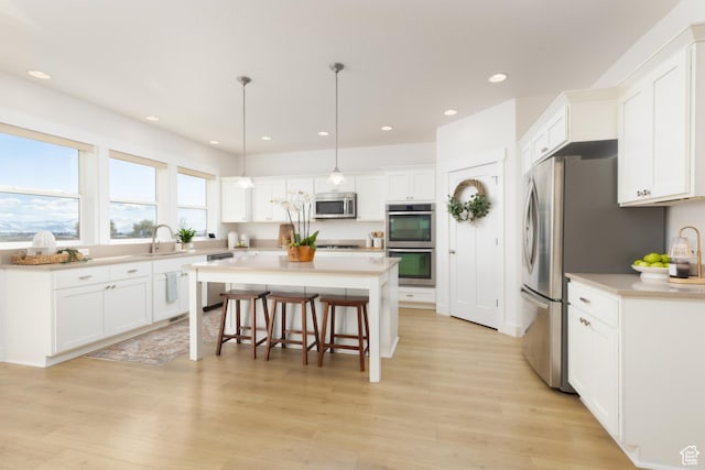 777 S Lake View Dr, Vineyard, UT 84059 - kitchen with stainless steel appliances, a kitchen island, a breakfast bar area, and white cabinets