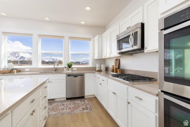 777 S Lake View Dr, Vineyard, UT 84059 - kitchen with recessed lighting, a sink, light wood-style floors, appliances with stainless steel finishes, and white cabinetry