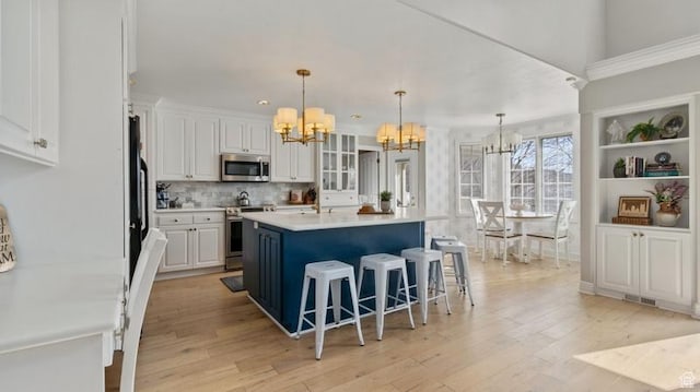 315 Stonehenge, Providence, UT 84332 - kitchen featuring light wood-style floors, stainless steel appliances, a notable chandelier, and white cabinetry