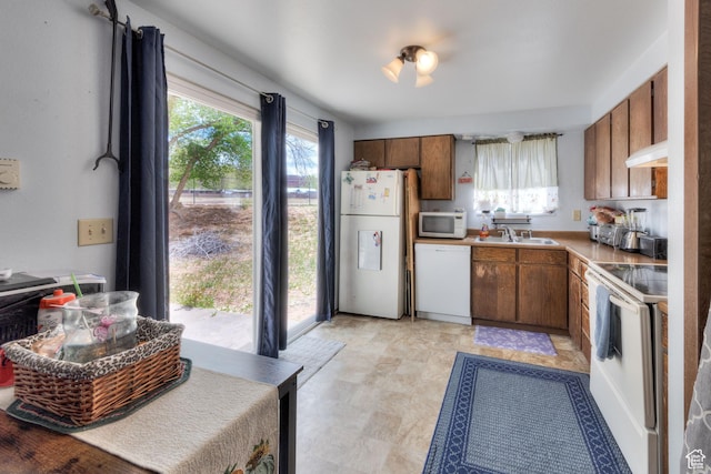 451 & Dr, Moab, UT 84532 - kitchen with white appliances, light countertops, brown cabinets, range hood, and a sink