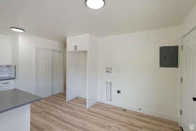 laundry room with baseboards, electric panel, light wood-style flooring, hookup for a washing machine, and hookup for an electric dryer