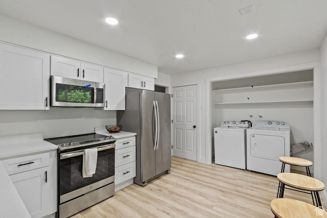 210 Ogden Cyn, Ogden, UT 84401 - kitchen with independent washer and dryer, light wood-style floors, appliances with stainless steel finishes, and white cabinetry