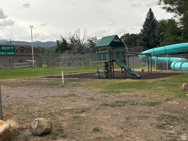 community playground featuring a lawn and fence