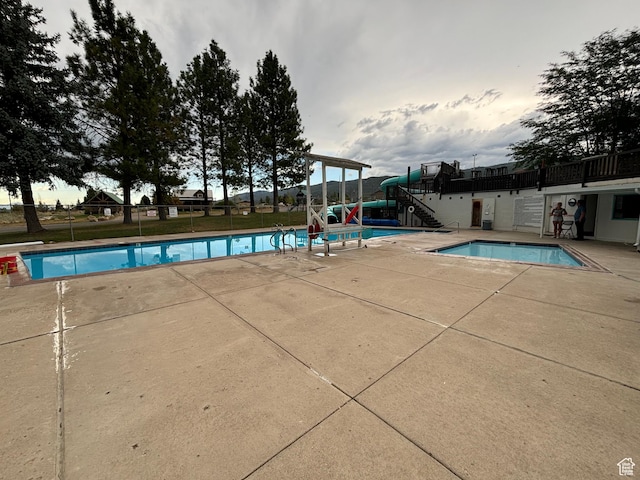 pool featuring a patio, stairs, and fence