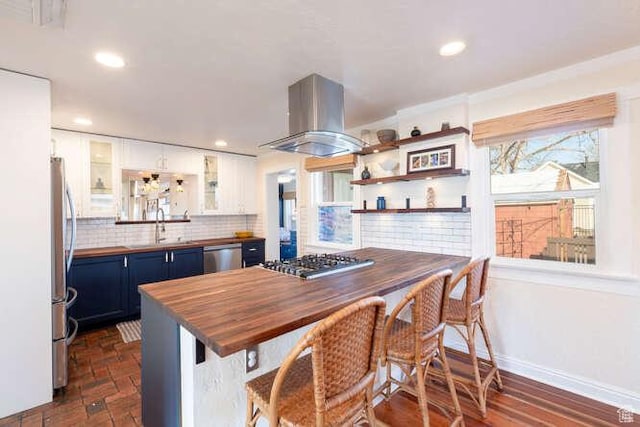 771 E Belmont Ave, Salt Lake City, UT 84105 - kitchen with island exhaust hood, blue cabinetry, appliances with stainless steel finishes, white cabinets, and butcher block counters
