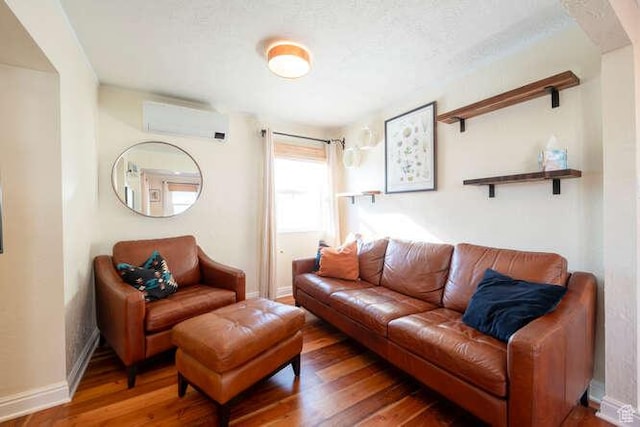 771 E Belmont Ave, Salt Lake City, UT 84105 - living room featuring baseboards, a textured ceiling, an AC wall unit, and wood finished floors