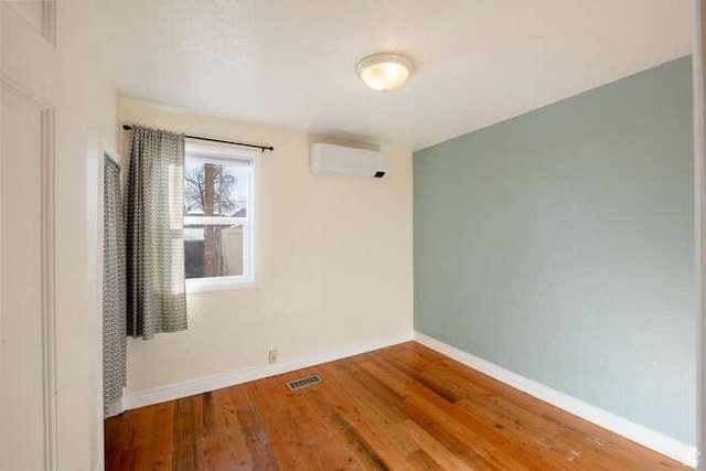 771 E Belmont Ave, Salt Lake City, UT 84105 - empty room with an AC wall unit, wood finished floors, baseboards, and visible vents