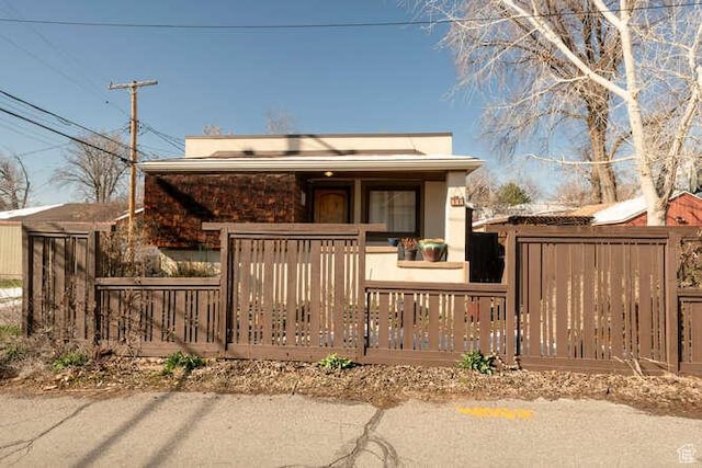 view of front of property featuring covered porch and fence
