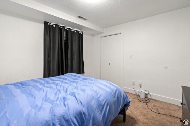 bedroom with visible vents, baseboards, carpet flooring, a textured wall, and a textured ceiling