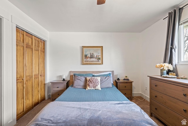 bedroom with dark colored carpet, a closet, baseboards, and ceiling fan