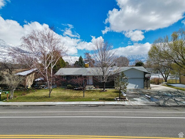 view of front of property featuring a garage, driveway, a chimney, and a front yard