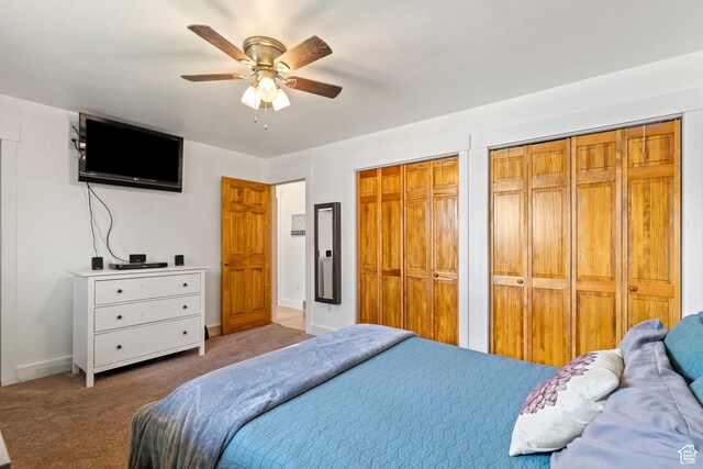 bedroom with carpet flooring, a ceiling fan, multiple closets, and baseboards