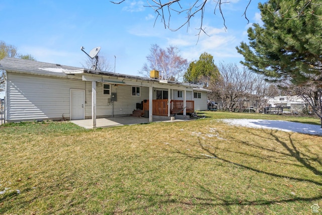 back of house featuring a deck, a patio, and a lawn