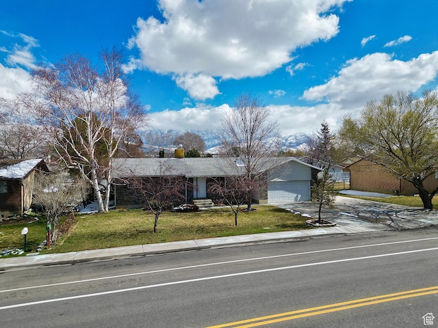 single story home with a front yard, a garage, and driveway