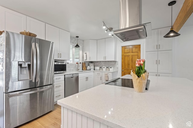 kitchen with island exhaust hood, decorative light fixtures, tasteful backsplash, stainless steel appliances, and white cabinets