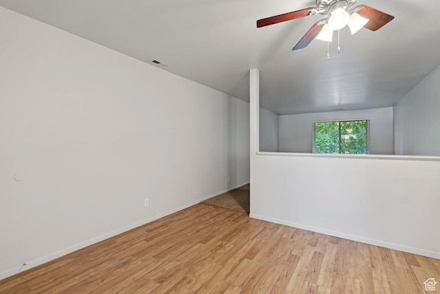 spare room with visible vents, baseboards, wood finished floors, and a ceiling fan