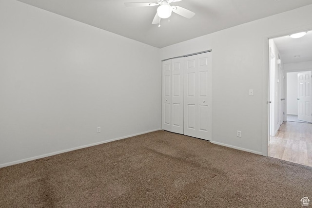 unfurnished bedroom with a closet, baseboards, carpet, and ceiling fan