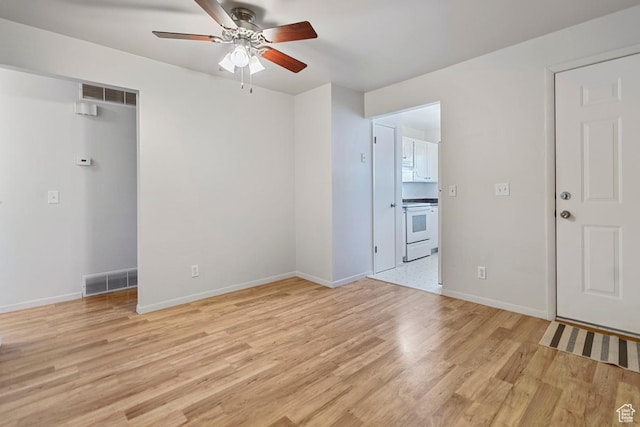 unfurnished room featuring light wood-type flooring, visible vents, baseboards, and ceiling fan