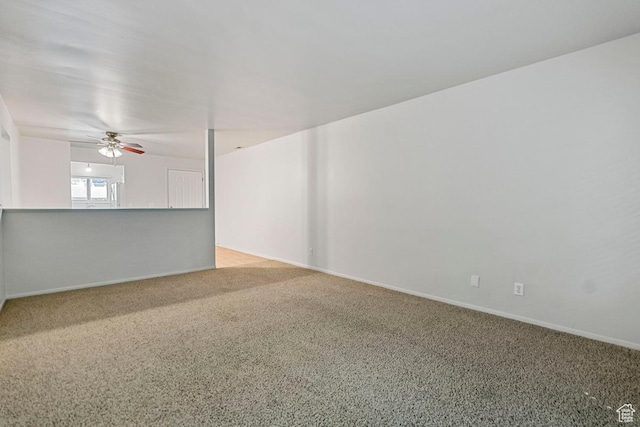 carpeted empty room featuring baseboards and ceiling fan