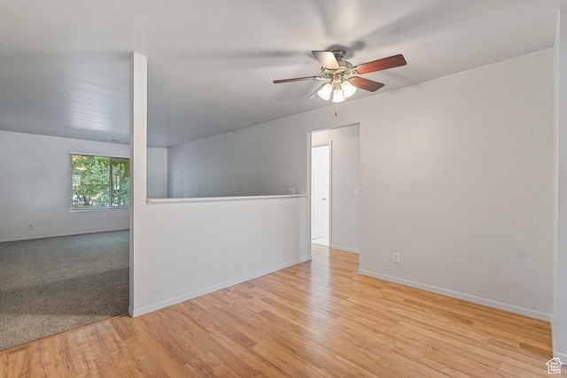 empty room with baseboards, light wood-style floors, and ceiling fan