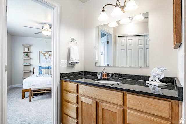 bathroom with vanity and ceiling fan with notable chandelier