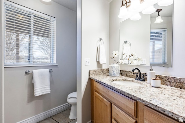 bathroom with tile patterned flooring, toilet, vanity, and baseboards