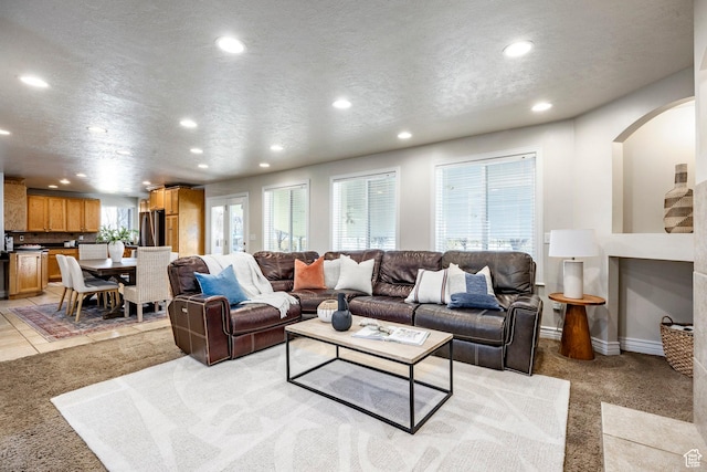 living area featuring recessed lighting, light colored carpet, a textured ceiling, and baseboards
